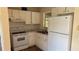 A well-lit kitchen features white cabinets, laminate countertops, and essential appliances for a functional cooking space at 2448 Austin Ave, Deltona, FL 32738