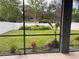 The backyard, as viewed from the lanai, includes a well-maintained lawn and colorful foliage at 1710 Summer Rose Dr, Mount Dora, FL 32757