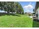 Expansive backyard with lush green lawn, mature trees, and a refreshing pool area at 3909 Corveta Ct, Orlando, FL 32837