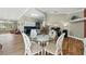 Dining area with a glass-top table, white chairs, and views of the kitchen and living areas at 3909 Corveta Ct, Orlando, FL 32837