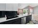 Modern kitchen with stainless steel appliances, dark cabinets, light countertop, and a view to the outdoor pool area at 3909 Corveta Ct, Orlando, FL 32837
