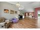 Bright, open living room with hardwood floors, eclectic decor, and a view into kitchen and dining area at 3909 Corveta Ct, Orlando, FL 32837