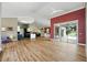 Spacious open-concept living area with wood flooring, connecting to the kitchen and featuring glass doors to the pool at 3909 Corveta Ct, Orlando, FL 32837