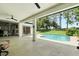 Spacious covered patio with ceiling fans, offering a view of the sparkling pool and beautifully maintained yard at 3909 Corveta Ct, Orlando, FL 32837
