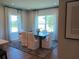 Formal dining area with a large table, elegant chairs, and large windows for natural light at 742 Copper Creek Dr, New Smyrna Beach, FL 32168