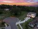 Stunning aerial view of a modern home on a spacious lot, surrounded by lush trees at sunset at 1841 Moorings Ct, Clermont, FL 34711
