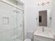 Bright bathroom featuring a glass-enclosed shower with marble tile and a modern vanity at 1841 Moorings Ct, Clermont, FL 34711