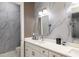 Elegant bathroom with marble-patterned walls, a double vanity, and stylish lighting fixtures at 1841 Moorings Ct, Clermont, FL 34711