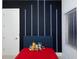 Stylish bedroom with a unique accent wall featuring modern lighting and playful decor with a red bedspread at 1841 Moorings Ct, Clermont, FL 34711