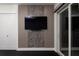 Sleek bedroom highlighting a modern TV accent wall and access to a private balcony through sliding doors at 1841 Moorings Ct, Clermont, FL 34711