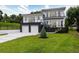 Beautiful two-story home with modern design, white exterior, dark accents, and a well-manicured lawn at 1841 Moorings Ct, Clermont, FL 34711