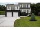 Modern two-story home featuring a clean white facade, dark accents, and well-maintained landscaping at 1841 Moorings Ct, Clermont, FL 34711