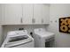 Bright laundry room featuring modern washer and dryer units, complemented by ample white cabinet storage at 1841 Moorings Ct, Clermont, FL 34711