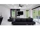 Modern living room with sleek black furniture, marble accent wall, and sliding glass doors at 1841 Moorings Ct, Clermont, FL 34711