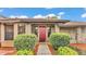 Charming single Gathering home with a well-manicured lawn, beautiful landscaping, and a red front door at 4120 Chelsea Ln, Lakeland, FL 33809