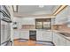 Bright kitchen featuring white cabinets, laminate wood floors, and stainless steel appliances at 4120 Chelsea Ln, Lakeland, FL 33809