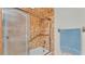 Bathroom featuring a shower with clear glass doors, a grab bar, and neutral tile at 4120 Chelsea Ln, Lakeland, FL 33809