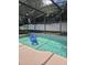 Backyard pool surrounded by a screened enclosure and mature trees at 15917 Mercott Ct, Clermont, FL 34714