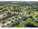 Scenic aerial view of a residential community with mature trees and well-maintained lawns at 4013 Greystone Dr, Clermont, FL 34711