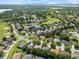 Community aerial with single Gathering homes, lush landscapes and recreational golf course nearby at 4013 Greystone Dr, Clermont, FL 34711