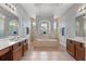 Bright bathroom features double vanity, soaking tub with window, and neutral tile at 4013 Greystone Dr, Clermont, FL 34711