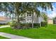Well-manicured front yard with lush landscaping and a charming home exterior at 4013 Greystone Dr, Clermont, FL 34711