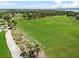 Scenic golf course with manicured greens, decorative plants, and a pristine walking path at 4013 Greystone Dr, Clermont, FL 34711