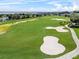 Scenic view of golf course featuring lush green grass, bunkers and walking paths at 4013 Greystone Dr, Clermont, FL 34711