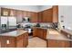 Functional kitchen with stainless steel appliances, wood cabinetry, and tile flooring at 4013 Greystone Dr, Clermont, FL 34711
