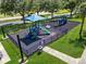Aerial view of modern playground with blue canopy, slides, and protective black ground cover at 4013 Greystone Dr, Clermont, FL 34711