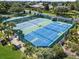 Aerial view of multiple fenced in and well-maintained tennis and pickleball courts at 4013 Greystone Dr, Clermont, FL 34711