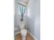 Powder room featuring neutral paint and fixtures and a blue decorative window treatment at 4013 Greystone Dr, Clermont, FL 34711