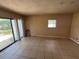 Light-filled bedroom featuring tile floors, neutral walls, and natural light from window and door at 507 Cloudcroft Dr, Deltona, FL 32738