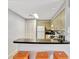 Bright kitchen with sleek black countertops, white appliances, and a breakfast bar with orange stools at 8601 Worldquest Blvd # 3404, Orlando, FL 32821