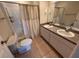 Bathroom featuring double sinks, ample counter space, a shower and tub with neutral-toned tile flooring at 888 W Stuart St, Bartow, FL 33830