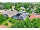 Aerial view of a home with solar panels, screened pool enclosure, and a lush green landscape with surrounding trees at 17426 Tailfeather Ct, Clermont, FL 34711