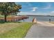 Boat ramp leading to a tranquil lake with a wooden pier and gazebo at 17426 Tailfeather Ct, Clermont, FL 34711