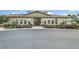 Community clubhouse featuring arched windows, double-door entrance, manicured landscaping, and ample parking space at 17426 Tailfeather Ct, Clermont, FL 34711