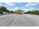 Community entrance with a gatehouse, landscaping, and an American flag displayed on a clear, sunny day at 17426 Tailfeather Ct, Clermont, FL 34711