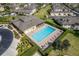 Aerial view of a community pool surrounded by well-manicured hedges, lounge chairs, and umbrellas at 17426 Tailfeather Ct, Clermont, FL 34711
