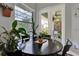 Cozy dining area featuring a black round table, large windows, and a view of the screened patio at 17426 Tailfeather Ct, Clermont, FL 34711