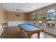 Bright game room featuring a blue billiard table, wood floors, wainscoting, and arched windows at 17426 Tailfeather Ct, Clermont, FL 34711