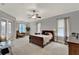 Spacious main bedroom features neutral paint, a ceiling fan, and multiple windows for natural light at 17426 Tailfeather Ct, Clermont, FL 34711