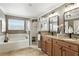 Bathroom featuring dual sinks, a soaking tub, and a glass-enclosed shower; great natural lighting at 1485 Waukon Cir, Casselberry, FL 32707