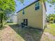 Exterior view of the backyard featuring a grill and grassy area with a view of the home's siding and windows at 938 Mansfield Rd, Tavares, FL 32778