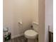 Convenient half-bathroom features a toilet, paper holder and room for storage beneath the counter at 938 Mansfield Rd, Tavares, FL 32778
