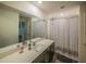 Bright bathroom featuring a large mirror, extended vanity, and a shower with a patterned curtain at 938 Mansfield Rd, Tavares, FL 32778