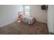 Bedroom offers cozy carpet, a sunny window, and ample space at 938 Mansfield Rd, Tavares, FL 32778