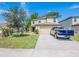 Charming two-story home featuring a spacious driveway and well-maintained lawn with a blue pickup truck at 938 Mansfield Rd, Tavares, FL 32778