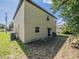 Exterior view showing the side and rear of the home, complete with a patio and landscaping at 938 Mansfield Rd, Tavares, FL 32778